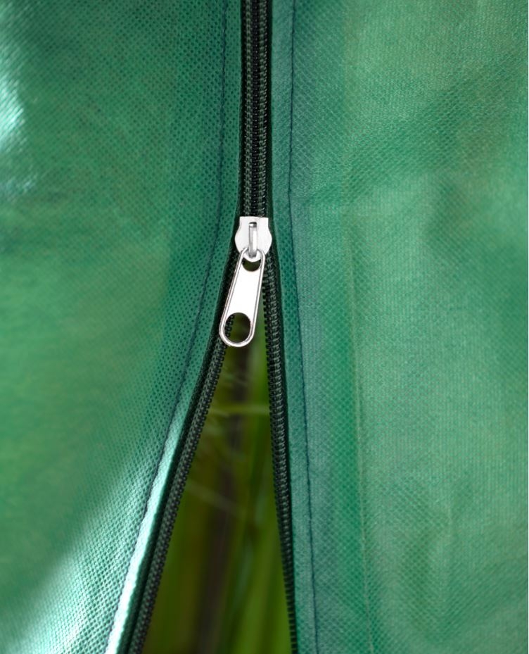 Close-up van een gesloten zilverkleurige rits op een groene stof.