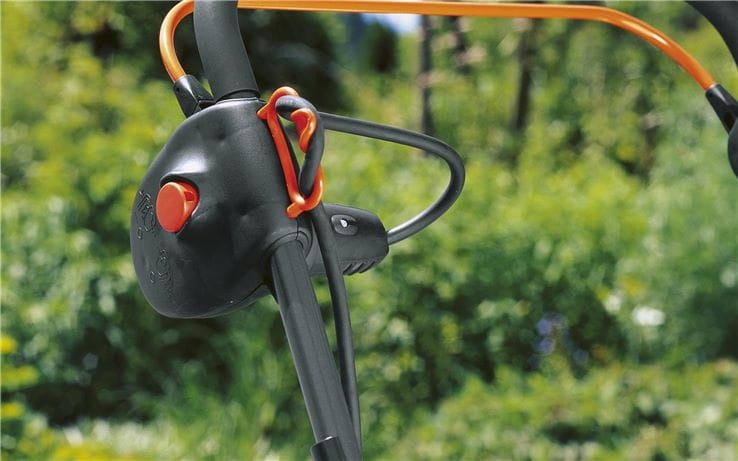 Detailopname van de Gardena Elektrische Gazonbeluchter ES 500: ergonomisch handvat met bedieningsknop en kabelgeleider.